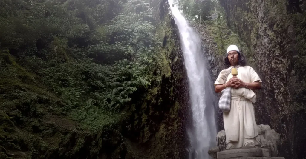 Mamo indígena de la Sierra Nevada con el fondo de una cascada